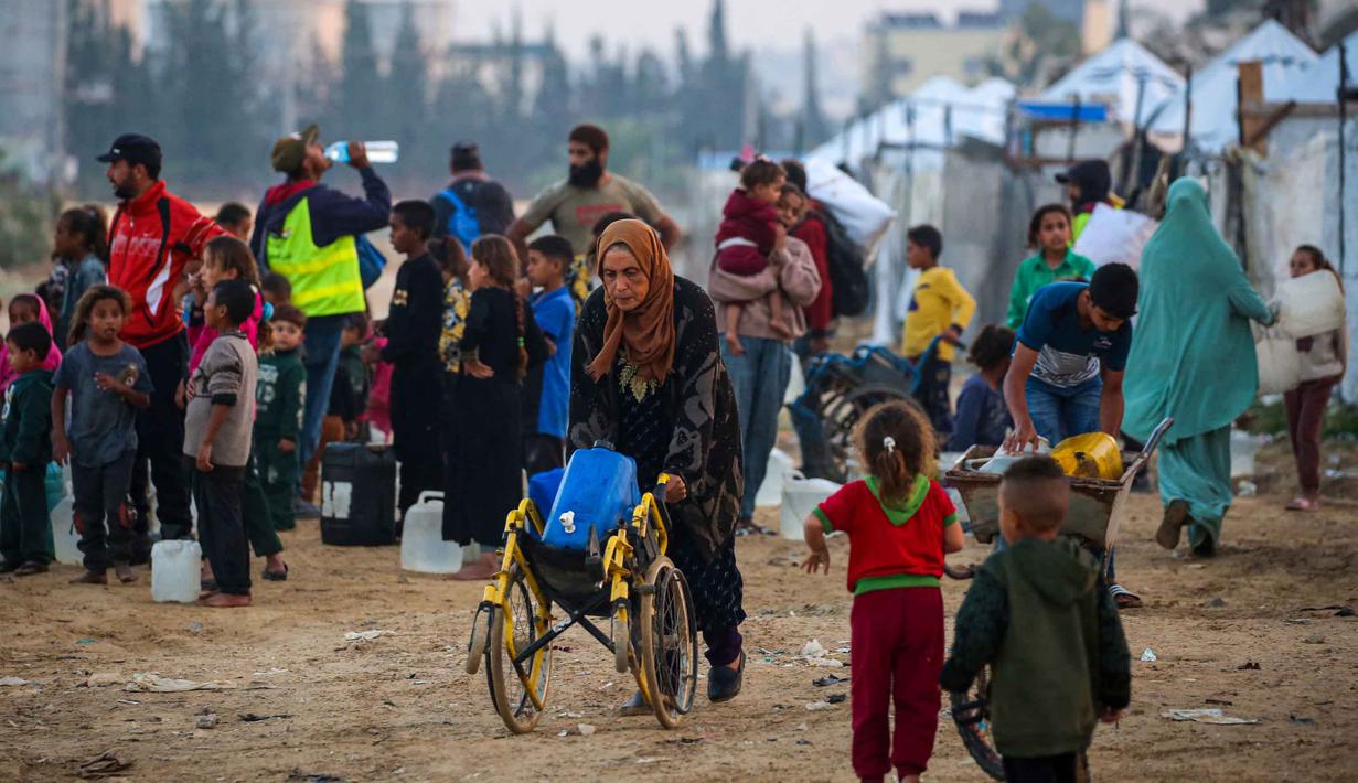Sebelumnya, pada September lalu, sebuah laporan Perserikatan Bangsa Bangsa memperingatkan bahwa persediaan air bersih di Gaza sangat terbatas dan sebagian besar yang tersisa telah tercemar. Tampak dalam foto, orang-orang mengisi wadah air mereka di kamp Nuseirat untuk pengungsi Palestina di Jalur Gaza tengah pada Kamis 4 Desember 2025. (Eyad Baba/AFP)