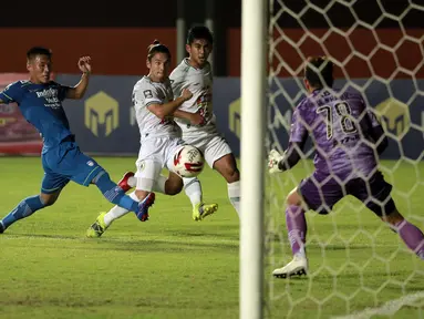 Pemain PS Sleman, Kim Jefferey Kurniawan (tengah) menendang bola ke gawang Persib Bandung yang dijaga I Made Wirawan dalam pertandingan semifinal leg pertama Piala Menpora 2021 di Stadion Maguwoharjo, Sleman, Jumat (16/4/2021). (Foto: Bola.com/Ikhwan Yanuar)