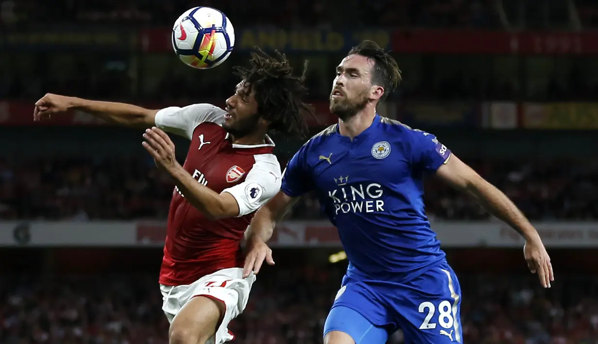 Gelandang Arsenal, Mohamed Elneny, duel udara dengan bek Leicester, Christian Fuchs,  pada laga Premier League di Stadion Emirates, London, Jumat (11/8/2017). Arsenal menang 4-3 atas Leicester. (AFP/Ian Kington)
