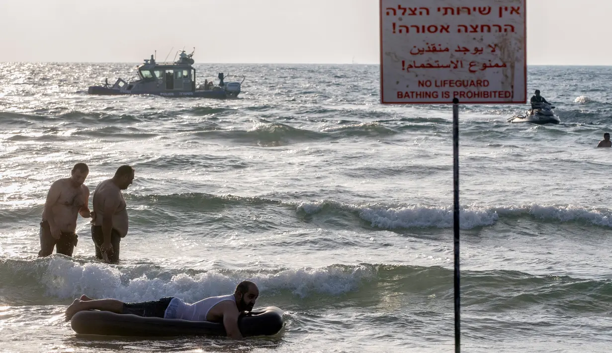 Sejumlah muslim bermain ombak saat menikmati libur lebaran di pantai laut Mediterania di Tel Aviv, Israel, 26 Jni 2017. (AFP PHOTO / JACK GUEZ)