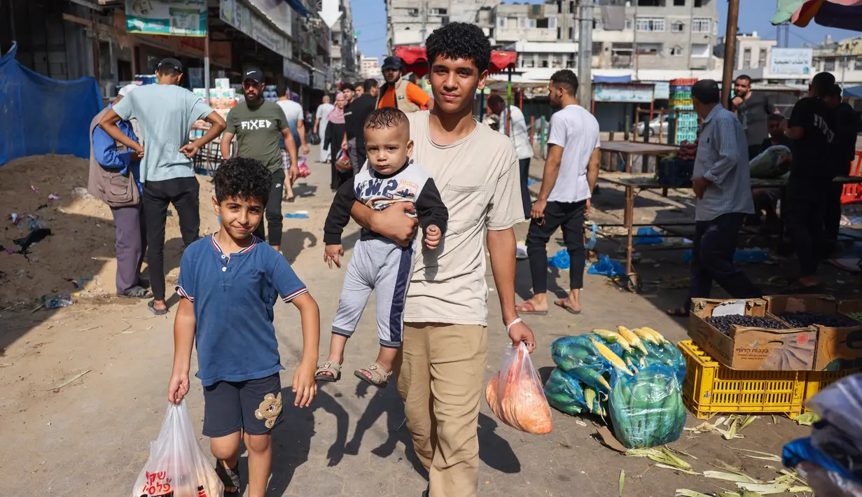 Orang-orang membeli produk segar di sebuah pasar di kota Gaza, pada 10 Oktober 2023. (Mohammed ABED / AFP)