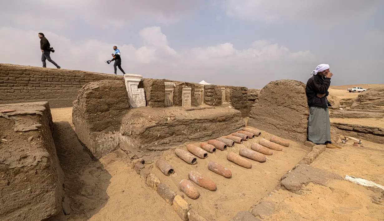 Anggota media berkumpul di daerah di mana lima makam Firaun kuno baru-baru ini ditemukan di situs arkeologi Saqqara, Kairo, Mesir (19/3/2022). Para arkeolog menemukan lima makam di timur laut piramida Raja Merenre I, yang memerintah Mesir sekitar tahun 2270 SM. (AFP/Khaled Desouki)