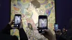 Orang-orang memotret 'Dame mit Faecher' (Lady with a Fan) karya Gustav Klimt saat dipajang di ruang lelang Sotheby's di London, Selasa (20/6/2023). (AP Photo/Kirsty Wigglesworth)