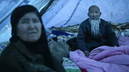 Para korban gempa berkerumun di tenda-tenda bantuan pada hari Rabu setelah suhu semalam jatuh jauh di bawah nol derajat Celcius. (Pedro Pardo / AFP)