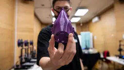 Teknisi Felipe Maturana menunjukkan masker yang dibuat menggunakan printer 3D di Santiago, Chile, (5/5/2020).  Pembuatan masker dengan printer 3D tersebut dilakukan sebagai upaya untuk melawan penyebaran virus corona Covid-19. (AFP/Martin Bernetti)