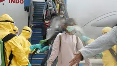 Petugas menyemprotkan cairan disinfektan ke WNI yang dievakuasi dari Wuhan, China saat tiba di bandara internasional Hang Nadim, Batam, Minggu (2/2/2020). Sebanyak 245 WNI di Wuhan dievakuasi ke Indonesia terkait merebaknya virus corona di kota tersebut. ((Photo by Handout/Indonesian Embassy/AFP)