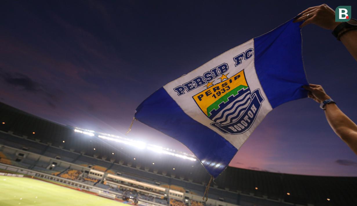 Seorang penonton membentangkan bendera Persib Bandung di tribun Stadion Utama Gelora Bandung Lautan Api (GBLA) menjelang laga pekan ketiga BRI Liga 1 2023/2024 antara Persib Bandung melawan Dewa United pada Jumat (14/07/2023). (Bola.com/Bagaskara Lazuardi)