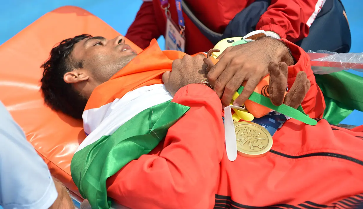 Atlet dayung India, Dushyant mendapat perawatan medis usai meraih medali perunggu pada final dayung kelas ringan tunggal putra Asian Games 2018 di Palembang, Sumatera Selatan, Jumat (24/8). (ANTARA FOTO/INASGOC/Nova Wahyudi/nym/18)