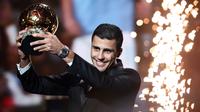 Pemain Manchester City, Rodri mengangkat trofi penghargaan Ballon d'Or 2024 pada acara yang berlangsung di Theatre du Chatelet, Paris, Selasa (29/10/2024) dini hari WIB. (AFP/Franck Fife)