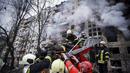 Petugas pemadam kebakaran mengevakuasi seorang pria dari gedung apartemen yang terkena tembakan di Kyiv, Ukraina (14/3/2022). Dua orang tewas pada 14 Maret 2022 akibat serangan penembakan dan rudal Rusia yang menghancurkan gedung apartemen tersebut. (Ukrainian State Emergency Service via AP)