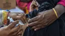 Petugas kesehatan menyuntikkan vaksin COVID-19 kepada seorang pekerja seks komersial (PSK) di Daulatdia, Bangladesh, 18 Agustus 2021. Bangladesh terus menggencarkan vaksinasi COVID-19, kegiatan ini turut menyasar para PSK di pusat prostitusi. (Munir Uz zaman/AFP)