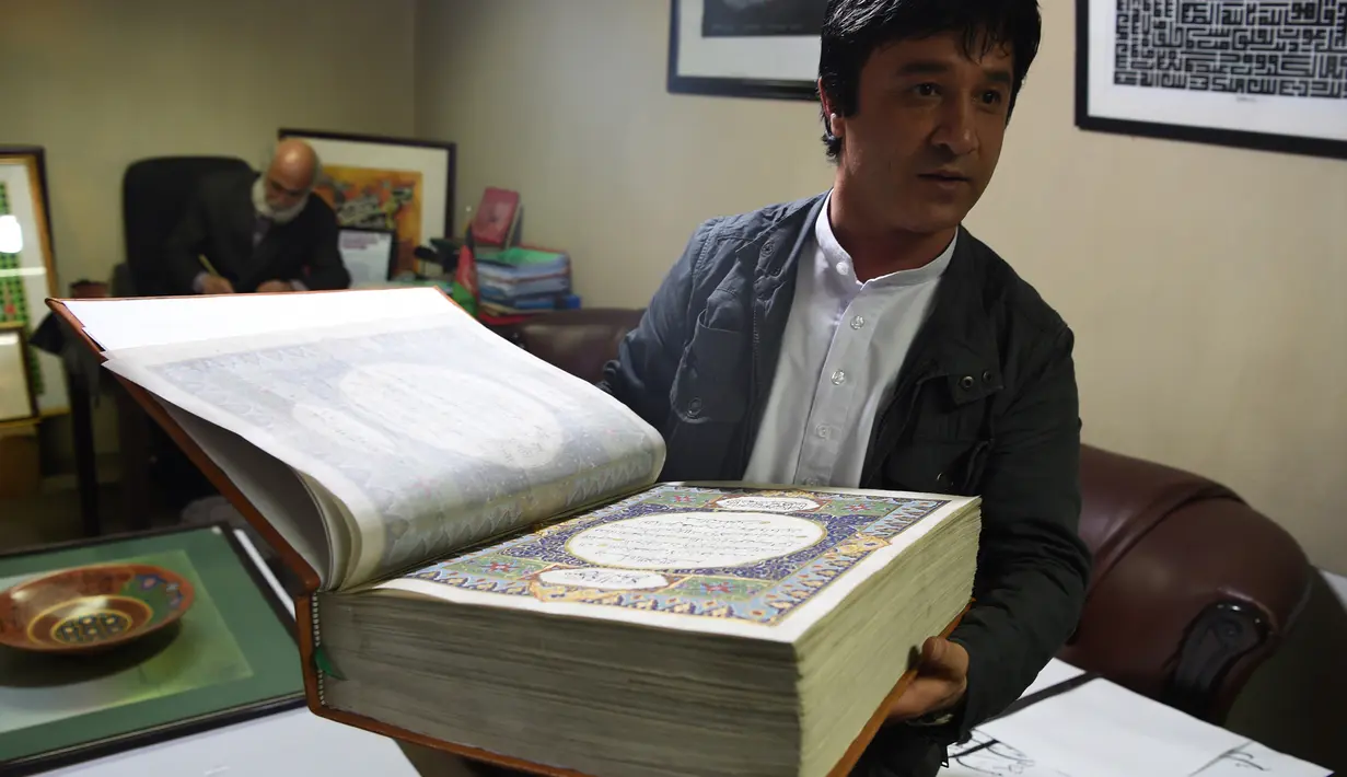 Seorang seniman Afghanistan, Abdull Sabur Omari menunjukkan Alquran buatan tangan di Mourad Khani, Kabul, Afghanistan (19/4). Kitab suci Alquran ini dibuat dengan tangan secara manual di atas kain sutra. (AFP/Wakil Kohsar)
