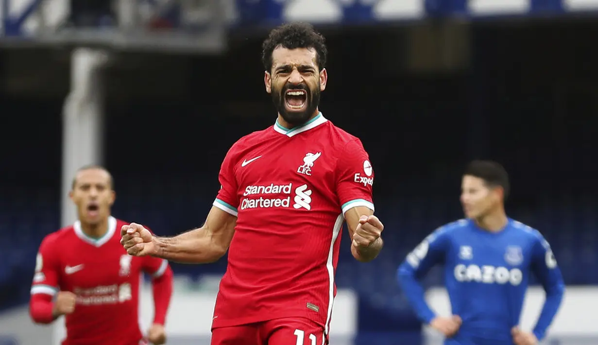 Pemain Liverpool Mohamed Salah (11) melakukan selebrasi usai mencetak gol ke gawang Everton pada pertandingan Liga Premier Inggris di Stadion Goodison Park, Liverpool, Inggris, Sabtu (17/10/2020). Pertandingan berakhir dengan skor 2-2. (Cath Ivill/Pool via AP)
