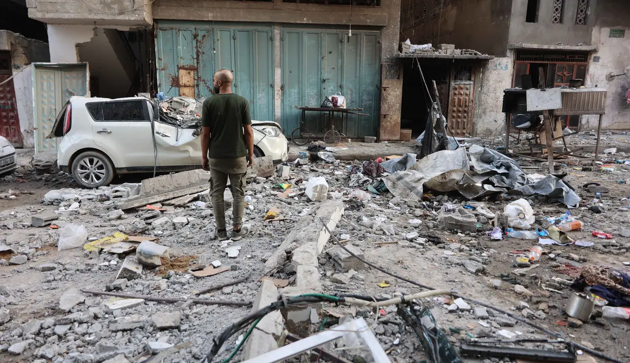 Seorang pria Palestina berdiri di tengah reruntuhan bangunan tempat tinggal dan mobil yang rusak setelah serangan Israel di Kota Gaza pada Kamis 4 Juni 2026. (Omar AL-QATTAA/AFP)