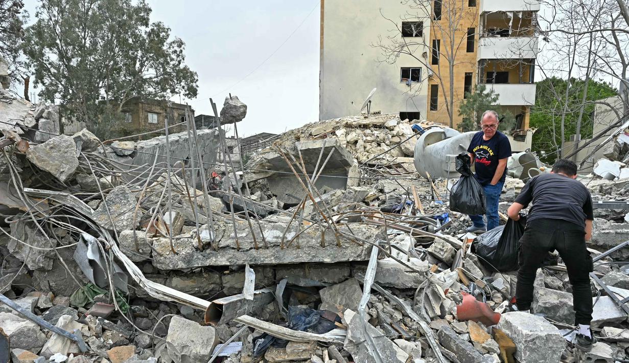 Sebagian besar pengungsi hidup dengan akses kebutuhan pokok yang terbatas. Tampak dalam foto, warga memeriksa puing-puing bangunan yang hancur saat kembali ke kota Nabatieh, Lebanon Selatan pada Sabtu 18 April 2026. (FADEL itani/AFP)