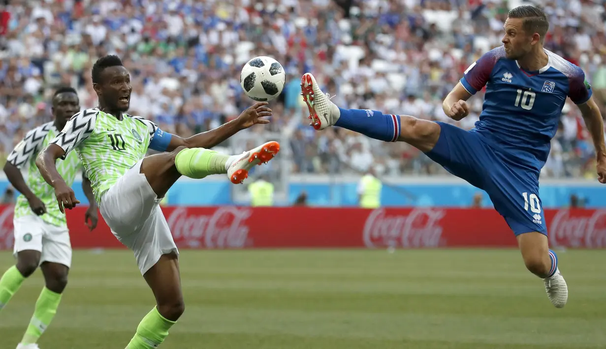 Duel pemain Nigeria, John Obi Mikel (kiri) dan pemain Islandia, Gylfi Sigurdsson pada laga grup D Piala Dunia 2018 di Volgograd Arena, Volgograd, Rusia, (22/6/2018). Nigeria menang 2-0. (AP/Darko Vojinovic)