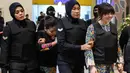 Tersangka kasus pembunuhan Kim Jong-nam, Siti Aisyah dan Doan Thi Huong, dikawal polisi menuju Bandara Internasional Kuala Lumpur, Selasa (24/10). Keduanya melakukan reka ulang kejadian di tempat keduanya dituding meracuni Kim Jong-nam. (MOHD RASFAN/AFP)