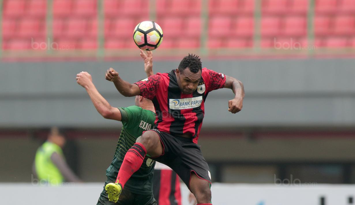 Aksi pemain Persipura Jayapura, Nelson Alom menyundul bola dari kejaran pemain PS TNI, Elio Martins pada lanjutan Liga 1 2017 di Stadion Patriot, Bekasi (4/11/2017). PS TNI menang 2-1. (Bola.com/Nick Hanoatubun)