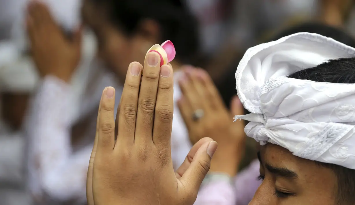 Umat Hindu bersembahyang saat Hari Raya Galungan di sebuah pura di Bali, Rabu (4/1/2023). Pada hari peringatan tersebut, umat Hindu akan memberi dan melakukan persembahan pada Sang Hyang Widhi dan Dewa Bhatara. (AP Photo/Firdia Lisnawati)