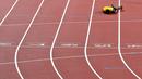 Pelari Jamaika, Usain Bolt terkapar di lintasan setelah terjatuh karena cedera di final 4x100 meter pada Kejuaraan Dunia Atletik di London, Sabtu (12/8). Bolt sempat tertatih-tatih sebelum akhirnya jatuh dan gagal melanjutkan lomba. (AP/Martin Meissner)