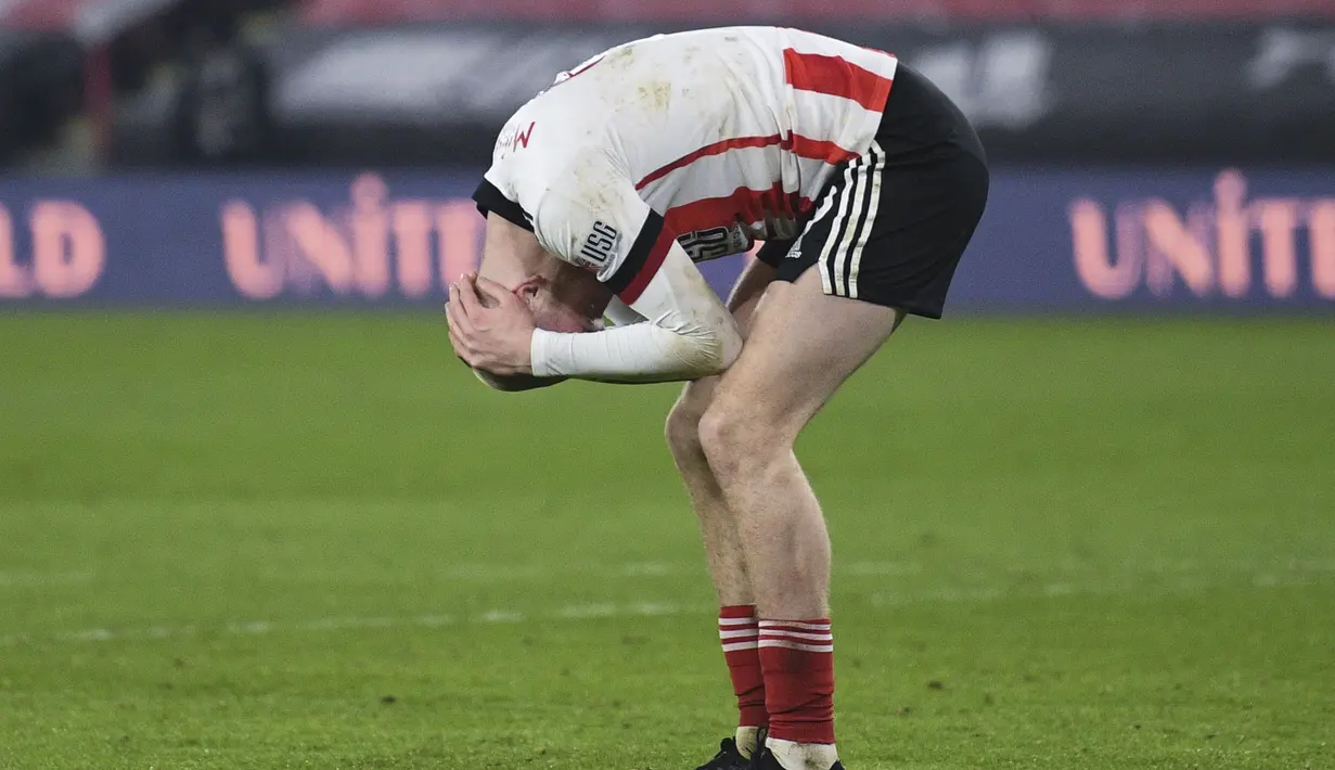 Pemain Sheffield United, Oliver McBurnie, tampak kecewa usai ditaklukkan Liverpool pada laga Liga Inggris di Stadion Bramall Lane, Minggu (28/2/2021). Liverpool menang dengan skor 2-0. (Oli Scarff, Pool via AP)
