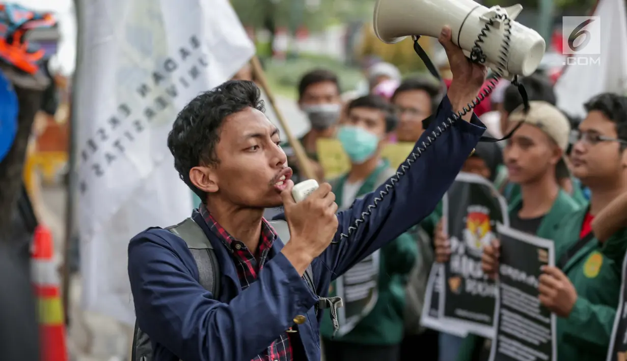 Seorang mahasiswa berorasi saat menggelar aksi di Gedung KPU, Jakarta, Selasa (23/4). Dalam Aksi #Mahasiswakawalkpu tersebut mendesak KPU RI segera menyelesaikan permasalahan pemilu dan responsif dalam menindak  aduan masyarakat demi tercapai pemilu yang bersih dan adil. (Liputan6.com/Faizal Fanani)