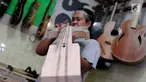 Pengrajin mengecek tingkat akurasi saat membuat gitar di Syukey Guitars, Cirendeu, Ciputat Timur (3/4). Gitar buatan tangan ini dipatok dengan harga Rp 5 juta hingga Rp 20 juta. (Merdeka.com/Arie Basuki)