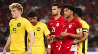 Pemain Timnas Indonesia U-23, Jens Raven (tengah) dan Kadek Arel mendapatkan penjagaan dari pemain Malaysia dalam laga Grup A Piala AFF U-23 2025 di Stadion Utama Gelora Bung Karno (SUGBK), Senayan, Jakarta, Senin (21/07/2025). (Bola.com/Abdul Aziz)