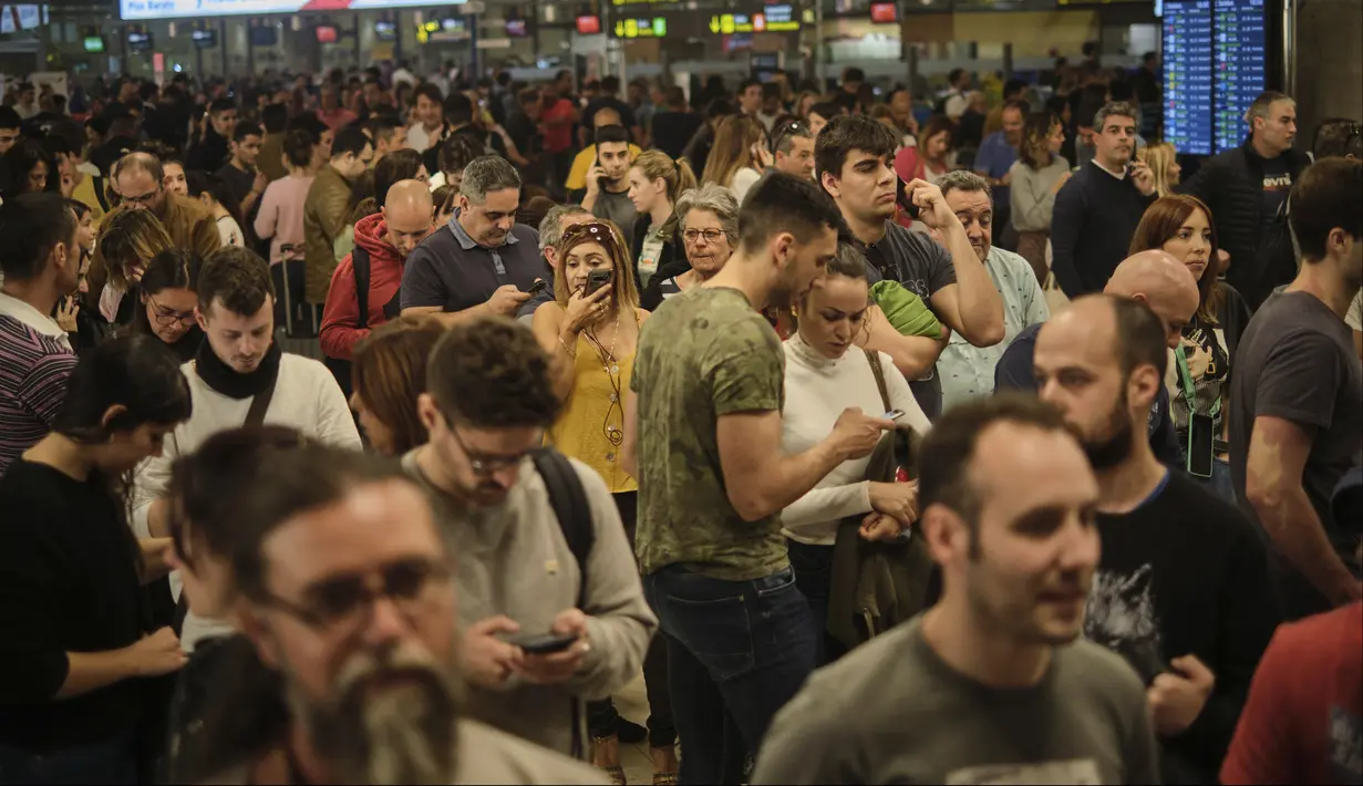 Penumpang mengantre di Bandara Santa Cruz de Tenerife saat badai pasir Gurun Sahara menerjang Kepulauan Canary, Spanyol, Minggu (23/2/2020). Kecepatan angin yang membawa badai pasir tersebut mencapai 120 km/jam. (AP Photo/Andres Gutierrez)