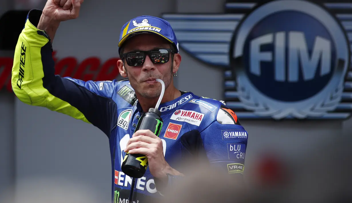 Pebalap Yamaha, Valentino Rossi, melakukan selebrasi saat balapan MotoGP 2018 di Sirkuit Catalunya, Spanyol, Minggu (17/6/2018). Lorenzo menjadi yang tercepat dengan catatan waktu 40 menit 13,566 detik. (AP/Eric Alonso)