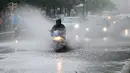 Pengendara motor melintasi genangan air akibat hujan deras di Berlin, Jerman, (29/6). Curah hujan yang tinggi yang mengakibatkan banjir telah menimbulkan kekacauan dalam transportasi di dalam kota. (Wolfgang Kumm / dpa via AP)