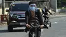 Pekerja kantor mengenakan pelindung saat mengendarai sepedanya di Manila pada 20 Mei 2020. Penjualan sepeda meroket menyentuh 300-500 unit dalam dua hari sejak pemerintah Filipina mulai melonggarkan langkah-langkah karantina yang dilakukan untuk mencegah penyebaran pandemi COVID-19. (Ted ALJIBE/AFP)