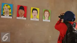 Pengunjung mengabadikan gambar tokoh anti korupsi dalam Pameran Peringatan Hari Anti Korupsi Oleh ICW di Histori Cafe, Kota Tua, Jakarta, Jum’at (9/12). (Liputan6.com/Gempur M Surya)