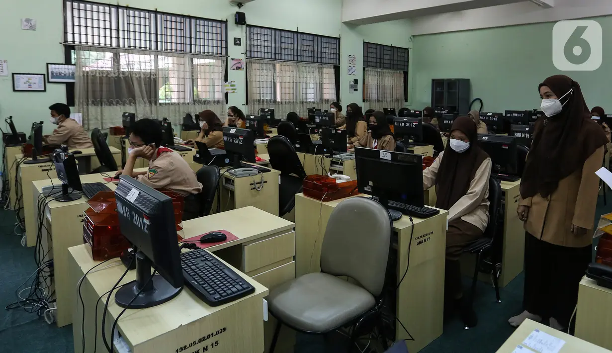 Pengawas mengecek selama pelaksanaan Asesmen Nasional  Berbasis Komputer (ANBK) 2021 di SMK 15, Jakarta, Rabu (22/9/2021). ANBK  SMK  digelar 20-23 September 2021 dengan mematuhi protokol kesehatan dan ANBK merupakan pengganti Ujian Nasional (UN). (Liputan6.com/Johan Tallo)