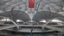 Sebuah bendera nasional Tiongkok digantung di terminal Bandara Internasional Beijing Daxing yang sedang dibangun di pinggiran Beijing, China (1/3). Bandara baru di ibu Kota China ini akan menjadi salah satu yang terbesar di dunia. (AP Photo/Ng Han Guan)