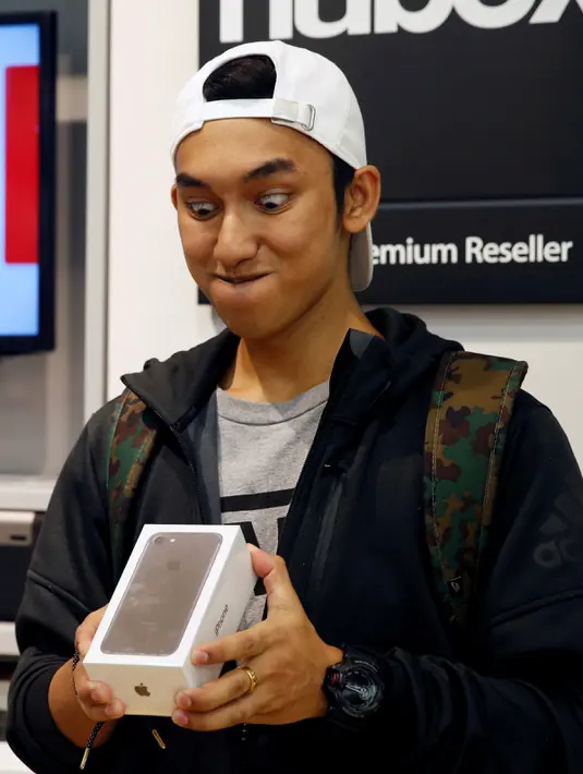 Ekspresi Kent Lee saat mendapat iPhone 7 di sebuah toko reseller Apple Singapura, Jumat (16/9). Pembeli iPhone7 hari ini menjadi bagian dari pembeli pertama di seluruh dunia. (REUTERS / Edgar Su)