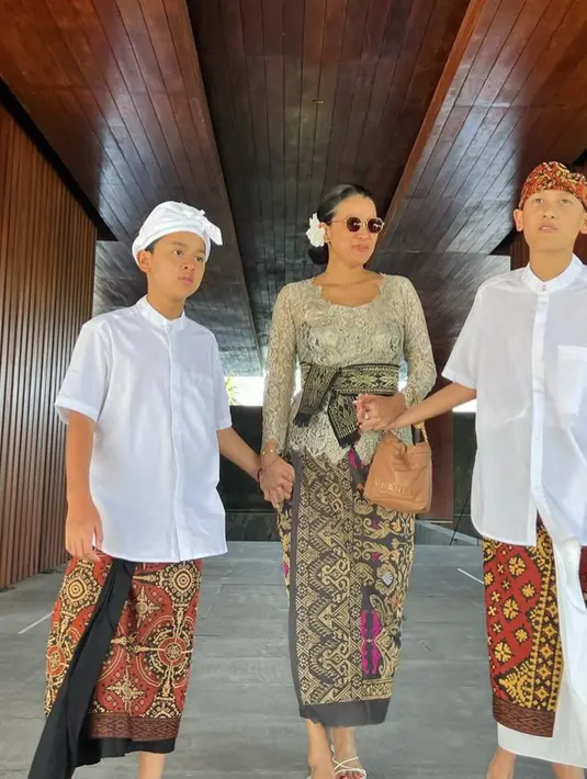 Mengenakan kacamata hitam, Marcella pun membawa handbag coklat dari Channel. Ia pun mengenakan heels strap putih.  [@marcella.zalianty]