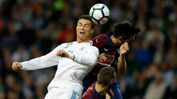 Pemain Real Madrid, Cristiano Ronaldo berebut bola dengan pemain Eibar, Paulo Oliveira dalam lanjutan La Liga pekan kesembilan di Stadion Santiago Bernabeu, Minggu (22/10). Madrid menang tiga gol tanpa balas. (AP/Francisco Seco)
