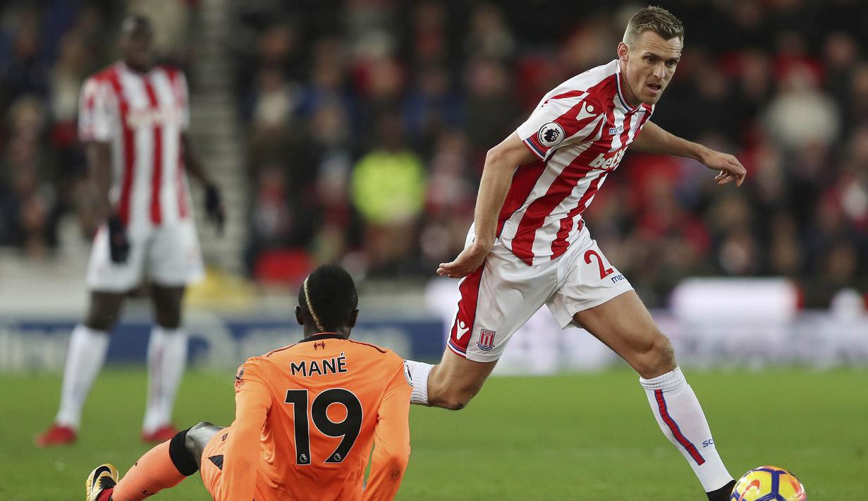 Gelandang Stoke, Darren Fletcher, melewati striker Liverpool, Sadio Mane, yang terjatuh pada laga Premier League di Stadion Bet365, Stoke-on-Trent, Rabu (29/11/2017). Stoke kalah 0-3 dari Liverpool. (AP/David Davies)