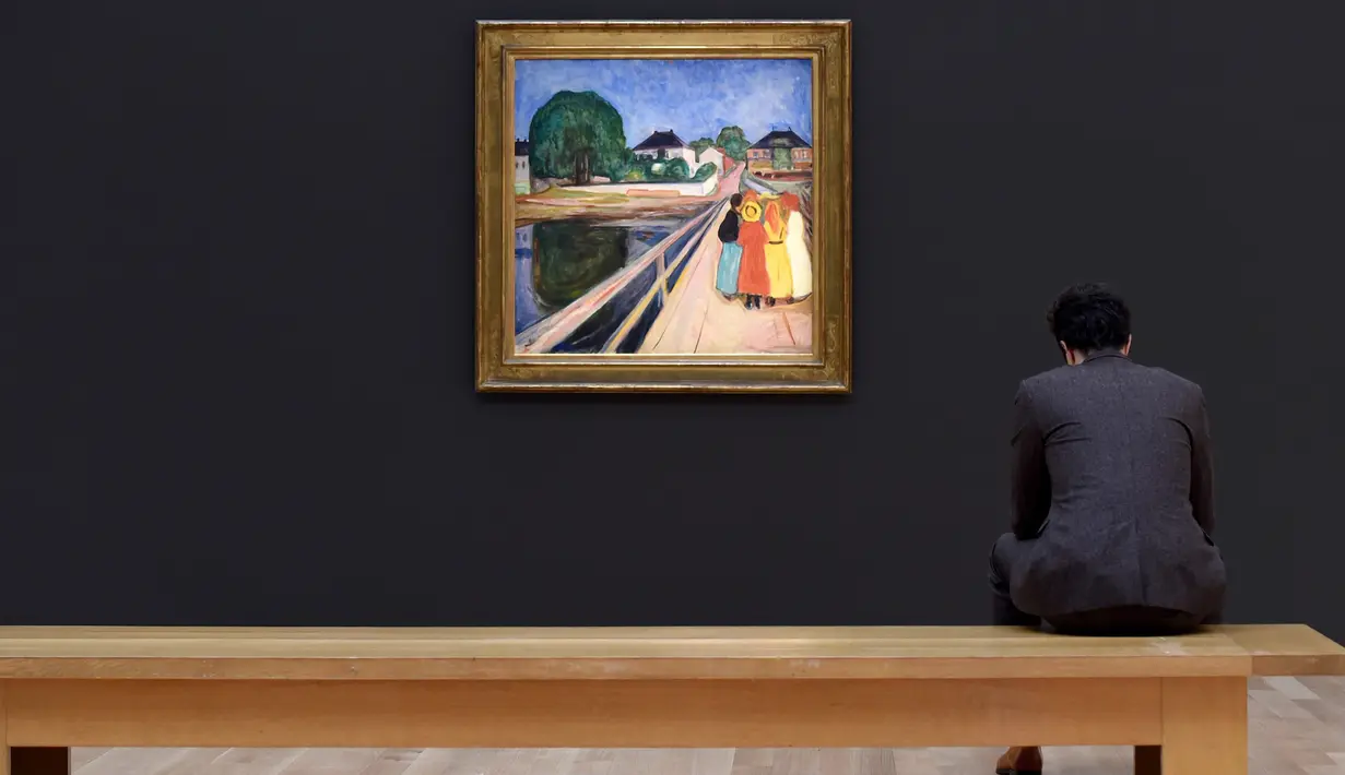 Pengunjung duduk dekat lukisan karya seniman Norwegia, Edvard Munch “Girls on the Bridge” di New York, 4 November 2016. Dalam sebuah lelang pada 14 November, lukisan dari 1902 itu terjual dengan harga USD54,5 juta (setara Rp727 M). (Timothy A. CLARY/AFP)