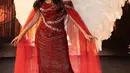 Titi DJ tampil penuh pesona bak peri dengan sebuah off-the-shoulder dress merah. Dress ini memiliki detail cape yang menjuntai dan sayap putih yang menambah nuansa megah pada keseluruhan penampilan Titi DJ. [Foto: Instagram/lisajuofficial]