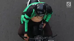 Pengendara sepeda motor mengoperasikan gawainya saat berkendara di Jakarta, Jumat (8/2). Mengoperasikan GPS saat mengemudi dinilai dapat mengganggu konsentrasi. (Liputan6.com/Immanuel Antonius)