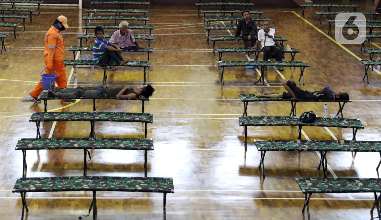 Petugas PPSU usai membersihkan lantai GOR Ciracas, Jakarta, Selasa (28/4/2020). Untuk mencegah meluasnya penyebaran virus Covid-19, Pemprov DKI Jakarta menyiapkan seluruh GOR di Jakarta untuk menampung sementara tunawisma. (Liputan6.com/Helmi Fithriansyah)