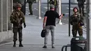 Tentara Belgia berbincang dengan seorang pria di luar Central Station usai sebuah teror ledakan yang terjadi di Brussels, Belgia (20/6). Media Belgia melaporkan bahwa ledakan terjadi di stasiun kereta api Gare Centrale. (AP Photo/Geert Vanden Wijngaert)