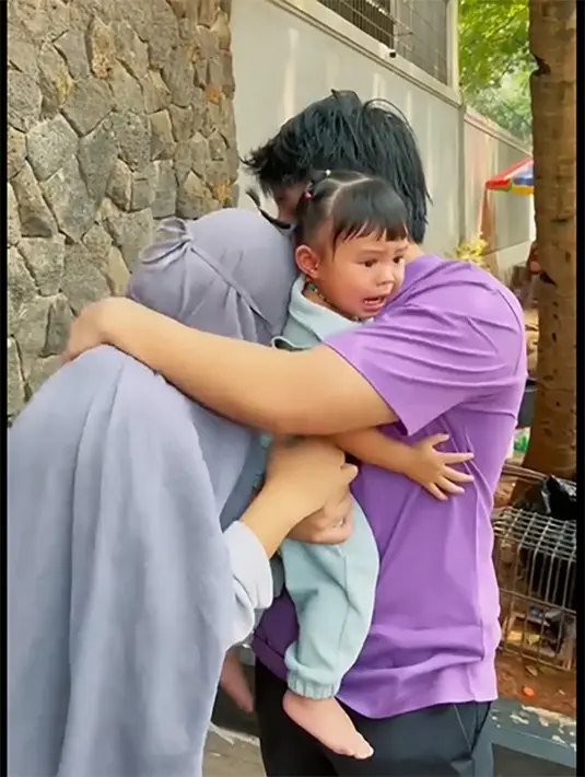 Atta Halilintar mengendong anaknya yang tak mau ditinggal Sus. Momen Atta memeluk sang istri yang juga sedih saat yang merawat putrinya izin libur dua minggu. Unggahan tersebut juga membuat  banyak netizen sedih. [Youtube/attahalilintar]