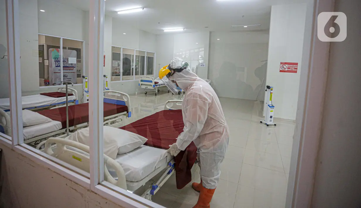 Petugas mengenakan hazmat saat menyiapkan tempat tidur di Tower 8 Wisma Atlet Pademangan, Jakarta, Selasa (15/6/2021). Tower 8 Wisma Atlet Pademangan bisa menampung 1.569 pasien untuk isolasi. (Liputan6.com/Faizal Fanani)