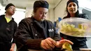 Seorang asisten memasak dengan down syndrome mempersiapkan menu makanan di dapur restoran "Le Reflet" di Nantes, Prancis Barat, 9 Februari 2017. Lelievre (26), mempekerjakan sejumlah karyawan yang memiliki down syndrome di restorannya. (LOIC VENANCE/AFP)