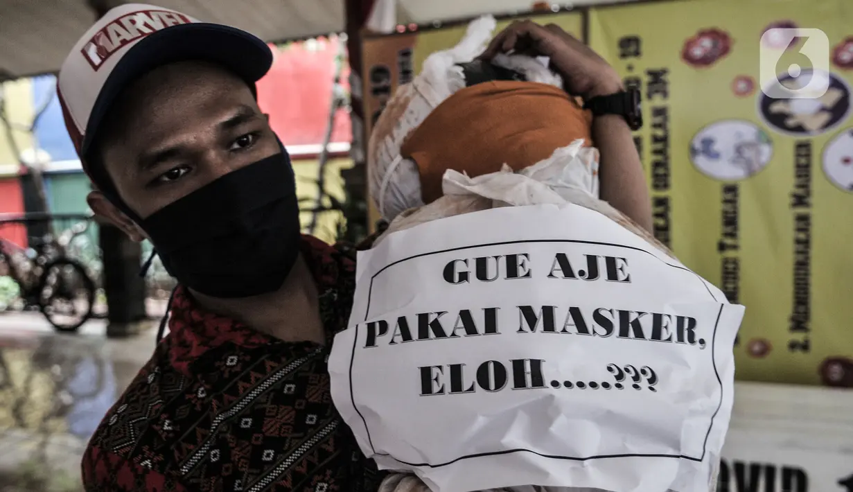 Pekerja memasang boneka pocong di Kantor Kecamatan Senen, Jakarta, Kamis (13/8/2020). Pemkot Jakpus menyiapkan peti mati dan boneka pocong untuk dipajang di setiap kecamatan sebagai peringatan akan bahaya Covid-19 dan imbauan untuk tidak mengabaikan protokol kesehatan. (merdeka.com/Iqbal Nugroho)