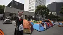 Sosok Presiden Meksiko Andres Manuel Lopez Obrador dengan tanduk seperti setan berdiri di sebuah kamp saat protes menuntut pengunduran dirinya di Juarez Avenue Mexico City, Mexico City, Senin (21/9/2020). (AP Photo/Fernando Llano)