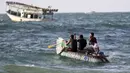 Nelayan Palestina, Mouad Abu Zeid dan teman-temannya menaiki perahu yang terbuat dari ratusan botol plastik bekas di sebuah pantai di Rafah, Jalur Gaza, 14 Agustus 2018. Perahu itu bisa mengangkut delapan nelayan ke tengah laut. (AFP/SAID KHATIB)